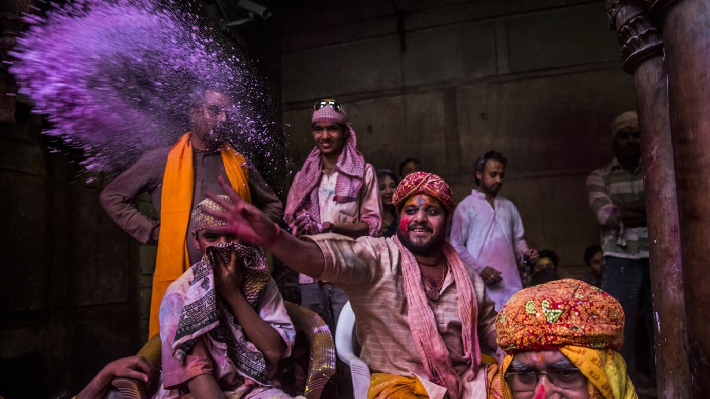A Hindu priest throws colored powder at devotees on March 26 in Vrindavan.