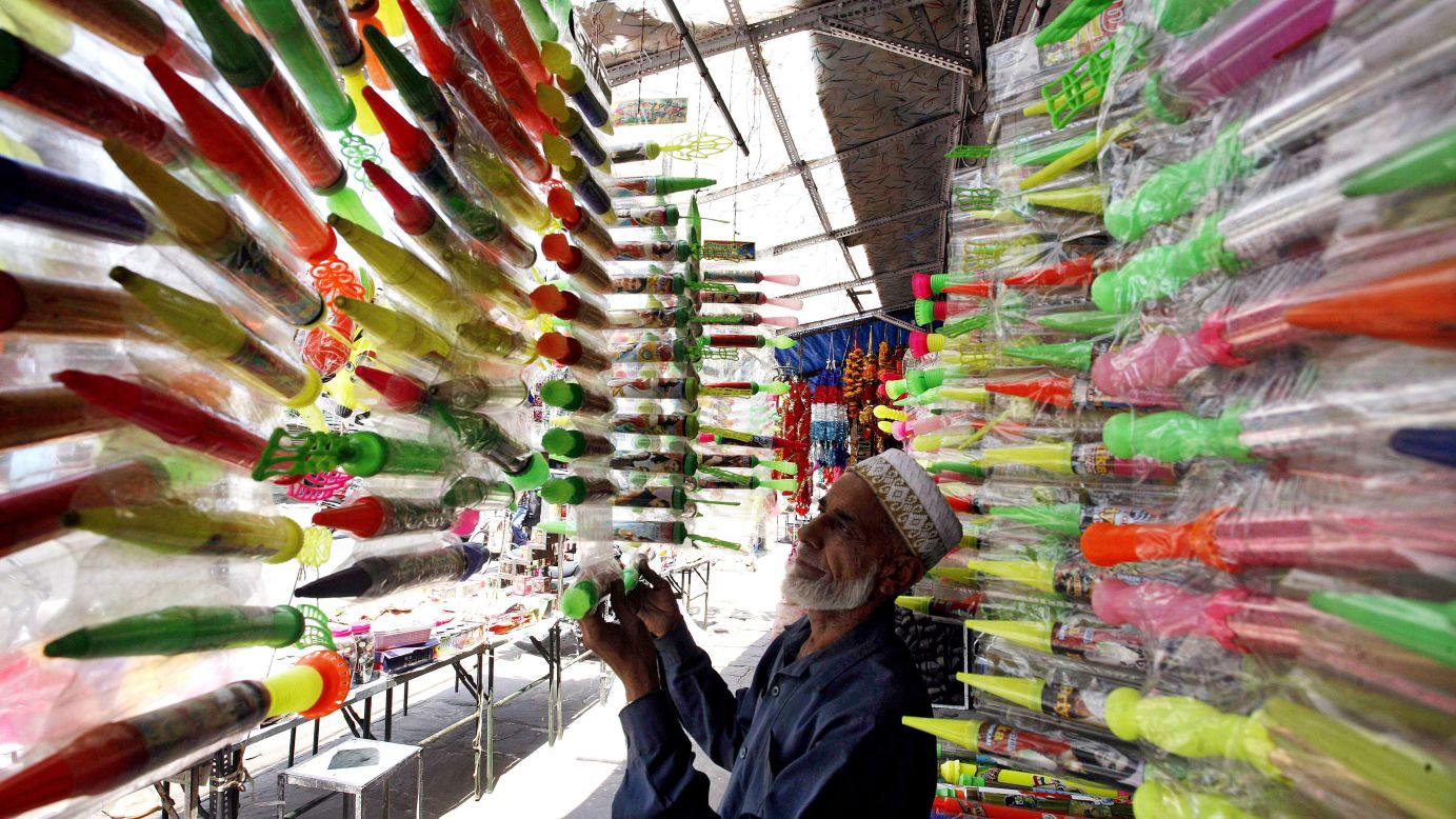 A shopkeeper sets up water canon for sale in a market ahead of the festival in Bhopal, India, on Monday, March 25.