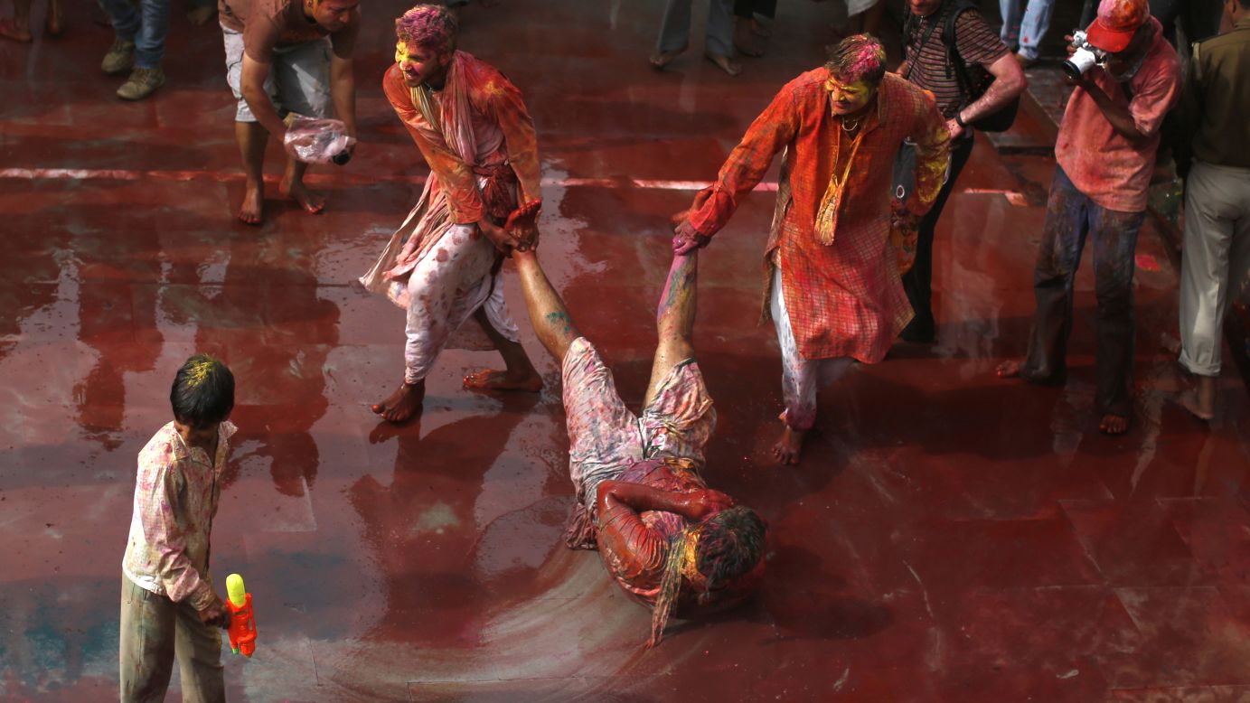 Men drag a boy on the ground to cover him in reddened water in Nandgaon, India, on Friday, March 22. Lathmar Holi takes place before Holi, officially, in the Nandgaon and Barsana villages and is deeply rooted in Hindu tradition, but Lathmar Holi revelry has taken place all over during the past week.