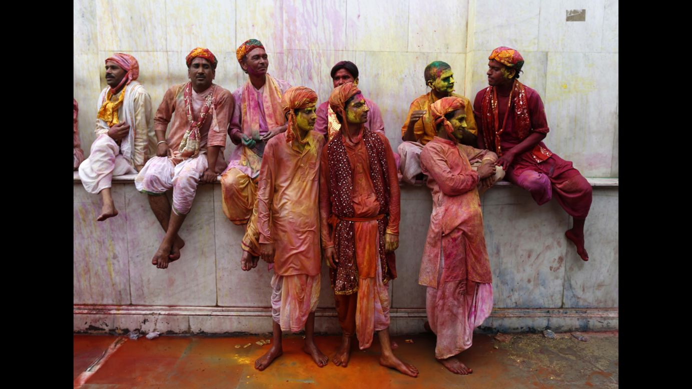 Men covered with colored powder and water stand inside a temple in Nandgaon, India, on March 22.