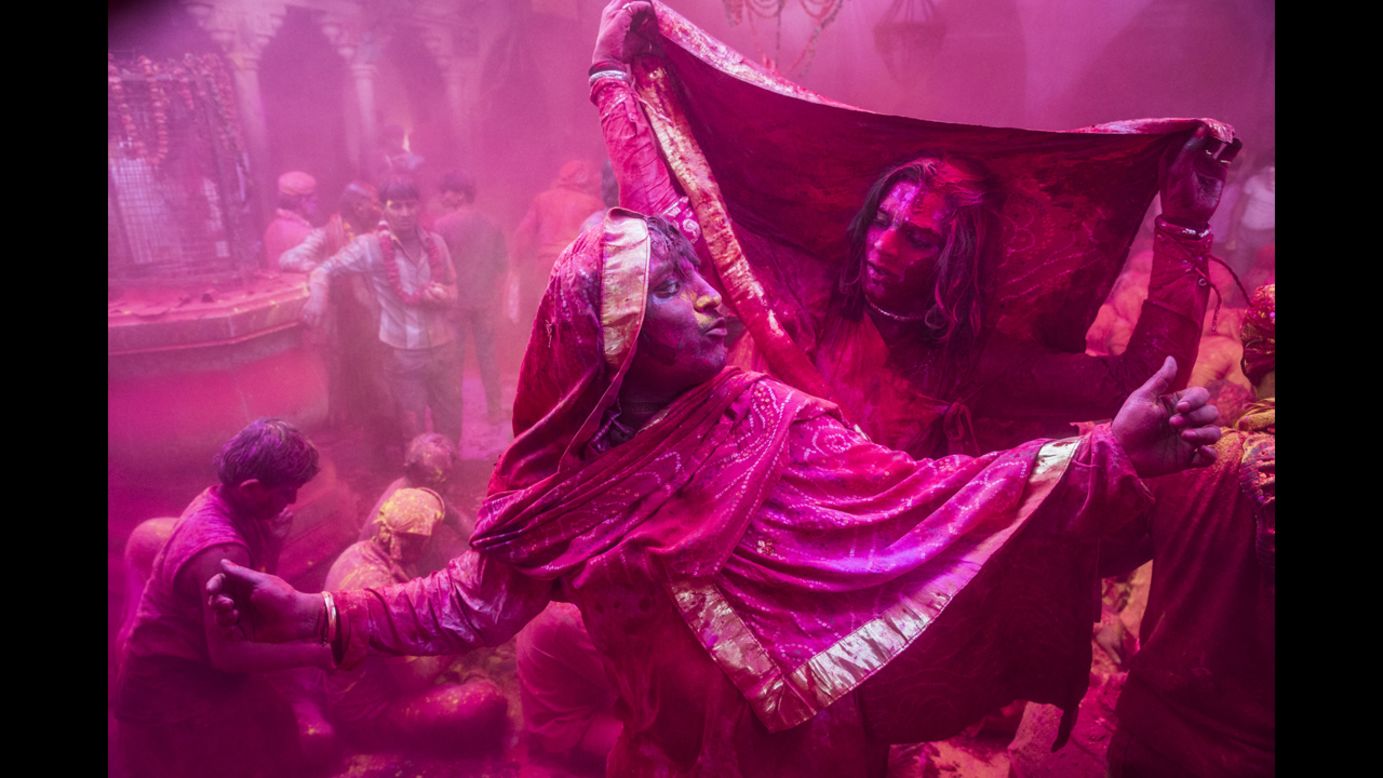 Transgender revelers dance as others play with color on March 21 in Barsana.