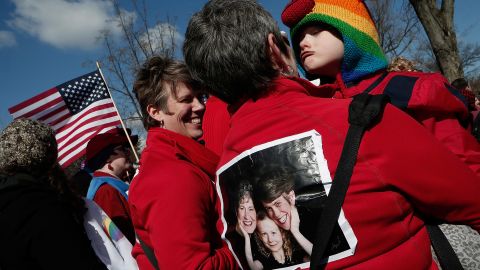The Rev. Rebecca Voelkel, left, partner Maggie George and their daughter Shannon Voelkel take part in Tuesday's demonstrations in front of the Supreme Court.
