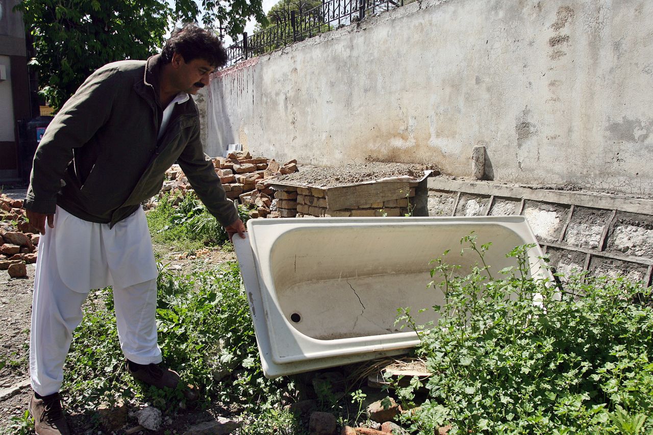 Contractor Yusufzai looks at a bathtub left over from the demolition on May 1, 2012.