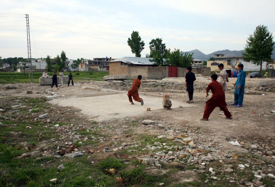 Children play cricket near the site of the demolished compound.