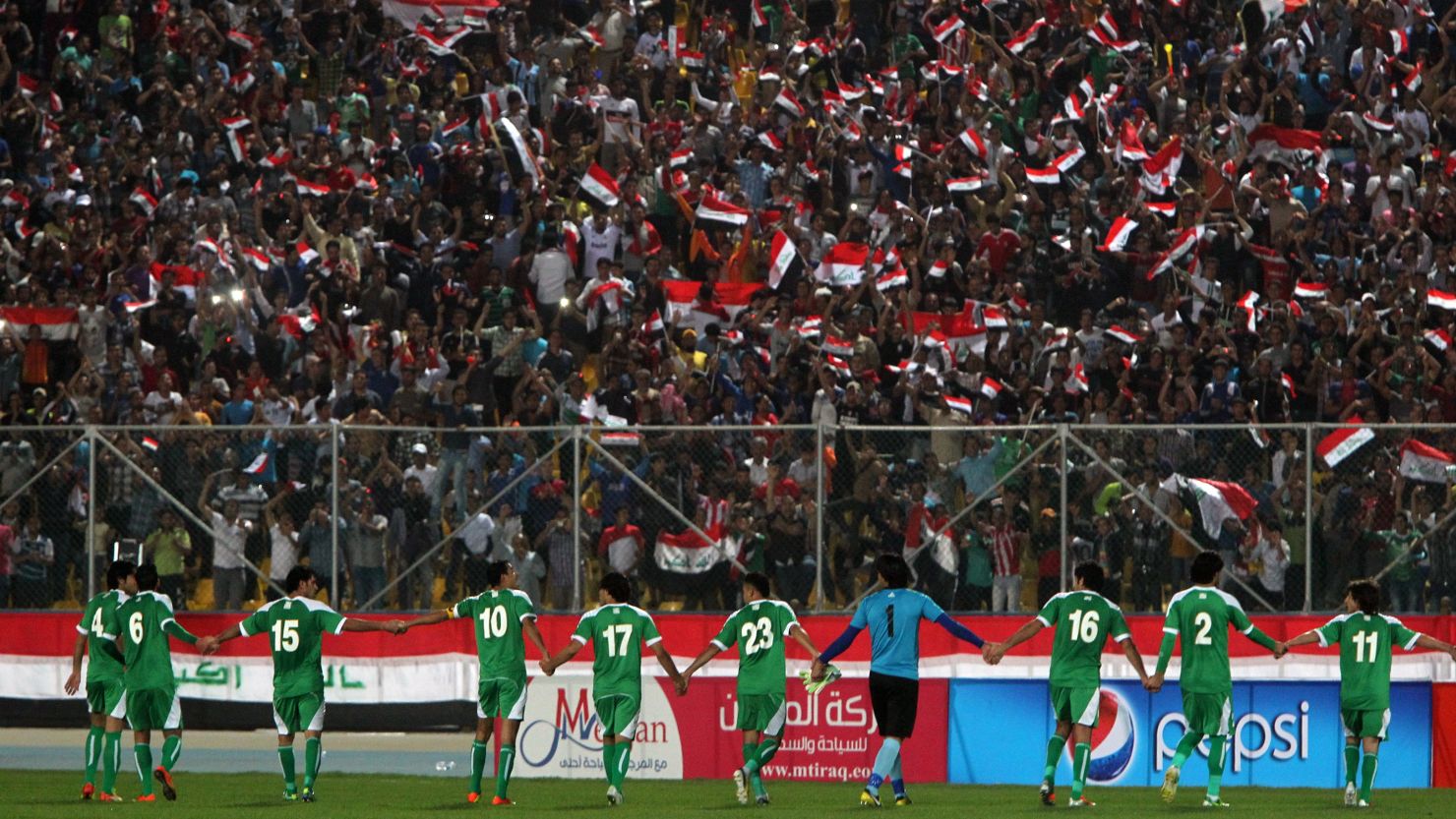 Iraqi team players celebrate after scoring a goal during their friendly soccer match against Syria in Baghdad.