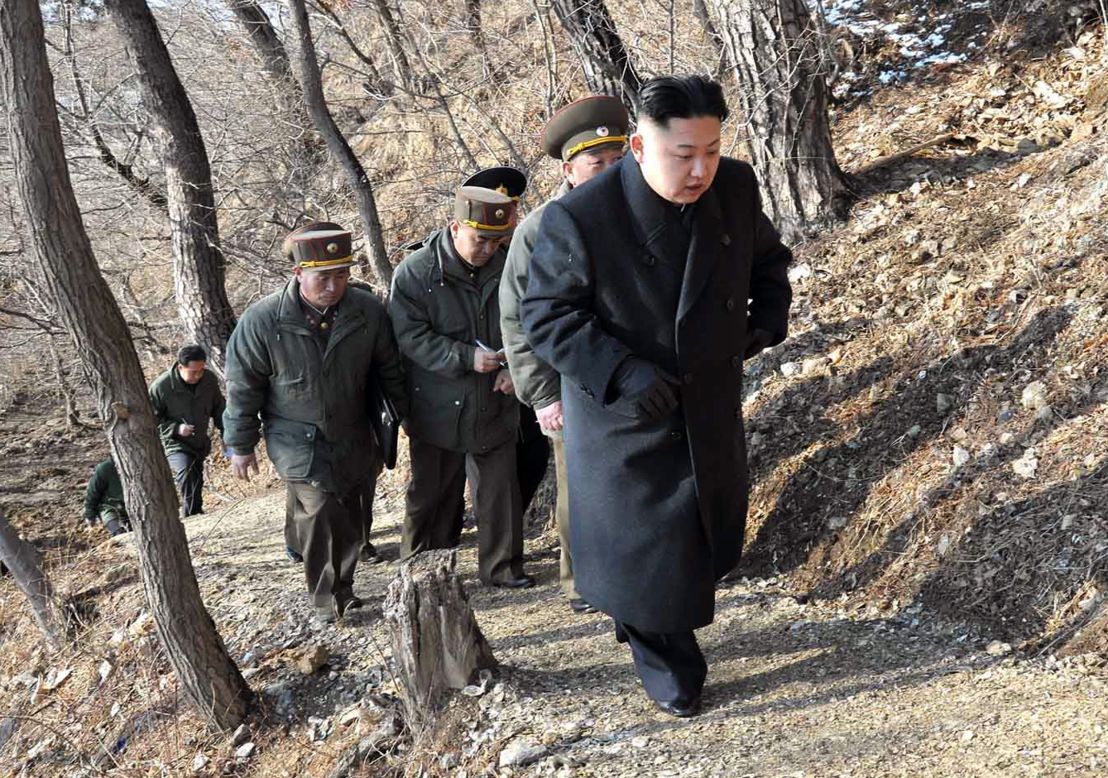 Kim, with North Korean soldiers, makes his way to an observation post in March 2013.