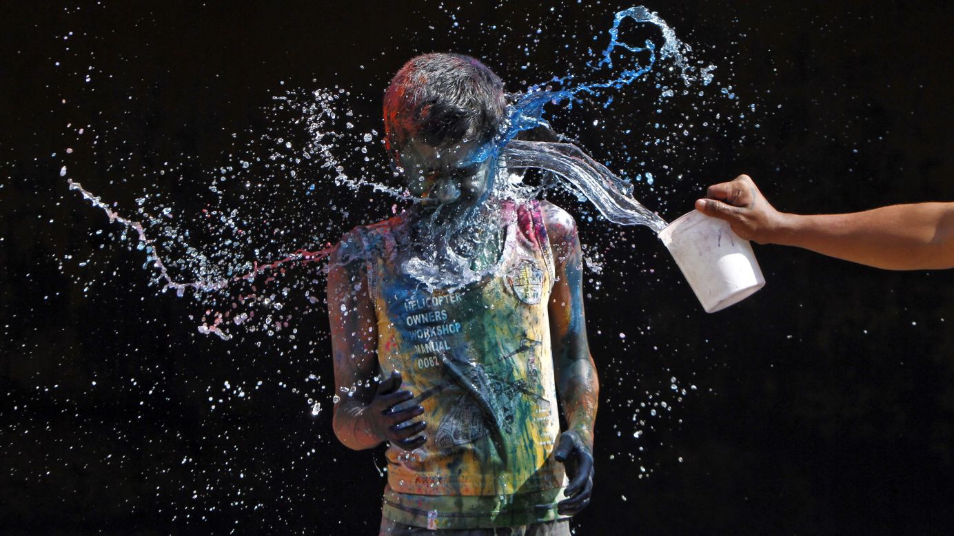 A boy splashes water on another boy smeared with colors in Chennai on March 27.