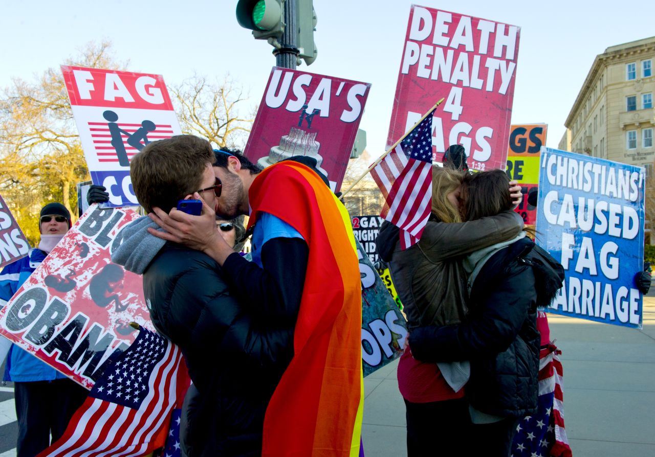 Same-sex couples kiss in front of protesters at the Supreme Court on Wednesday.
