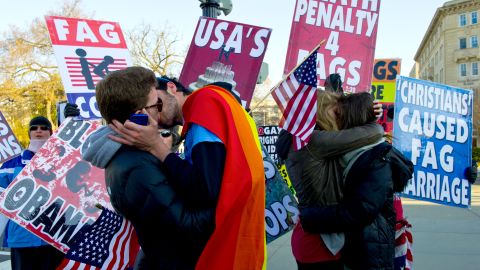 Same-sex couples kiss in front of protesters at the Supreme Court on Wednesday.