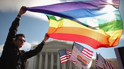 George Washington University student Eric Breese waves a rainbow flag outside the court Wednesday.