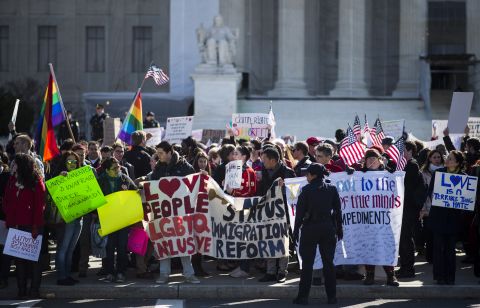 Supporters of same-sex marriage wave flags and signs as they rally in front of the U.S. Supreme Court on Wednesday, March 27, in Washington. The justices heard two cases this week related to state and federal laws restricting same-sex marriage.