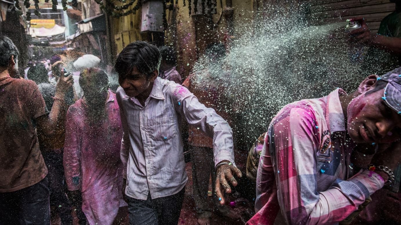 A man sprays a colored substance from an aerosol can on passersby during Holi on March 27 in Vrindavan.