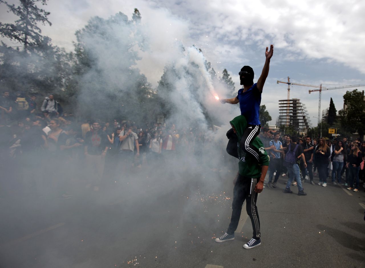 Cypriot college students light a flare outside the presidential palace during a protest on March 26.