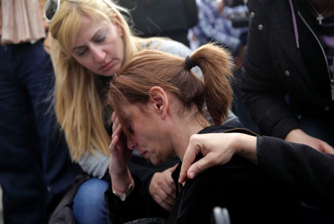 Employees of the Bank of Cyprus comfort one of their colleagues during a demonstration outside the main office of the bank in Nicosia on Tuesday, March 26.