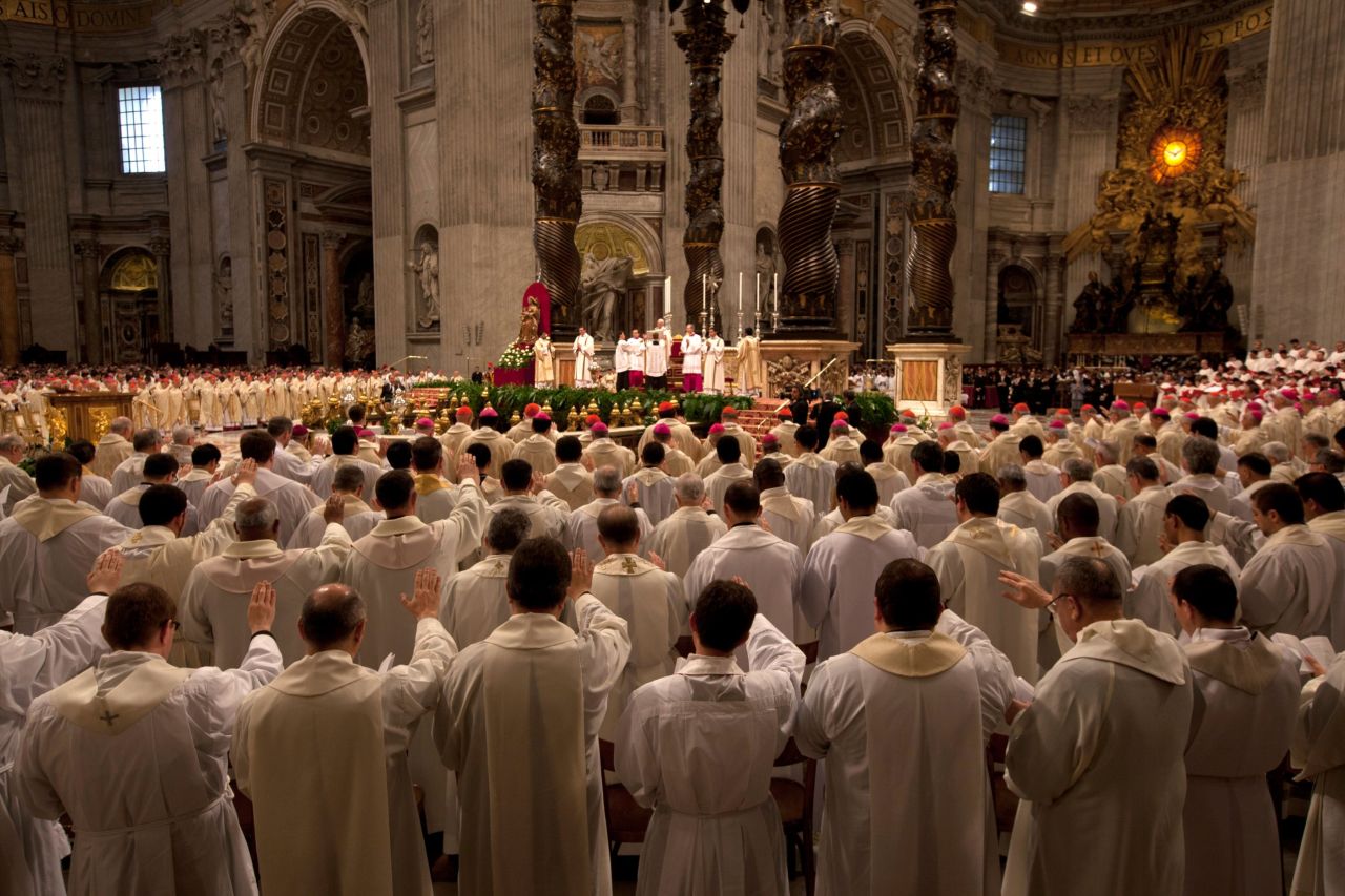 Church leaders signal to the front of the church during the Chrism Mass on Thursday.