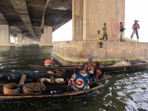 Women and children congregate under the Third Mainland Bridge, which connects Lagos Island with Nigeria's mainland. Many who live in Lagos and cross the bridge have never been to Makoko. 