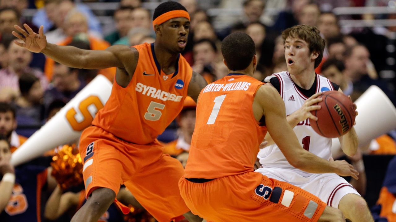 Jordan Hulls of Indiana handles the ball against Michael Carter-Williams, center, and C.J. Fair, left, of Syracuse on March 28.