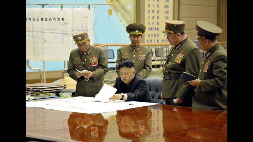 Kim Jong Un being briefed by his generals 
(Photo: On the left side of the photo there is a white paper with lines which appears to be a map. The title in Korean of the map goes ìPlan for the strategic forces to target mainland U.S.î If you view it carefully, there is a line leading to what appears to be Hawaii, California, and mainland U.S.) )
