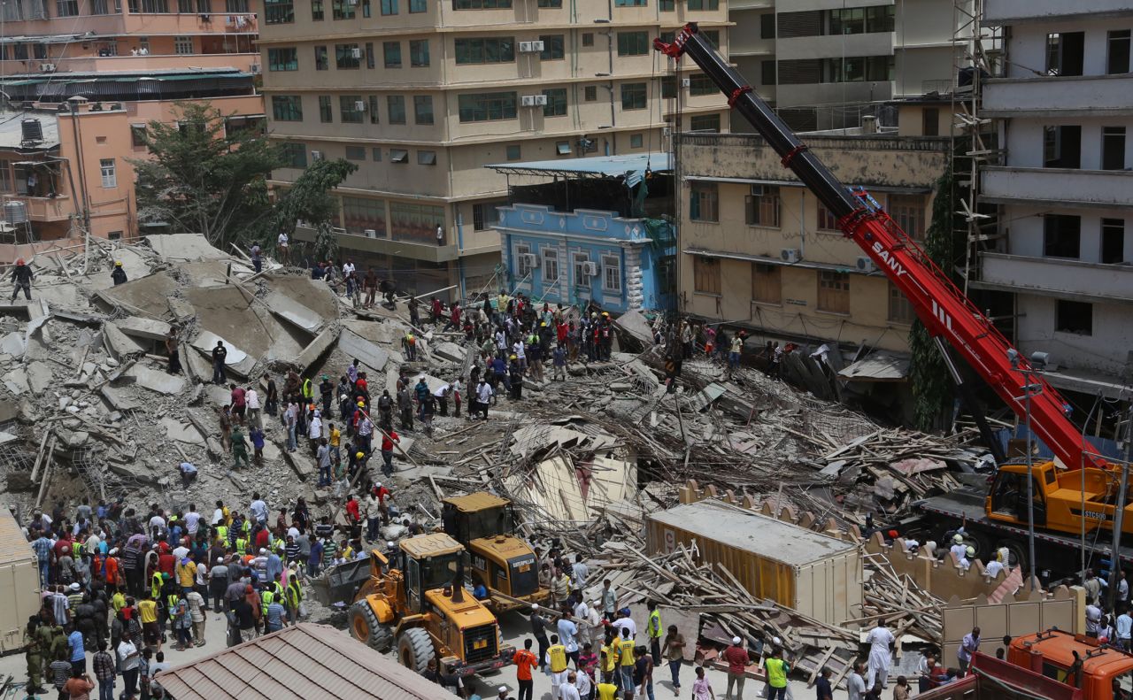 Rescue workers search for survivors as bystanders watch, after a building under construction in the Kariakoo district of central Dar es Salaam, Tanzania, collapsed on March 29.