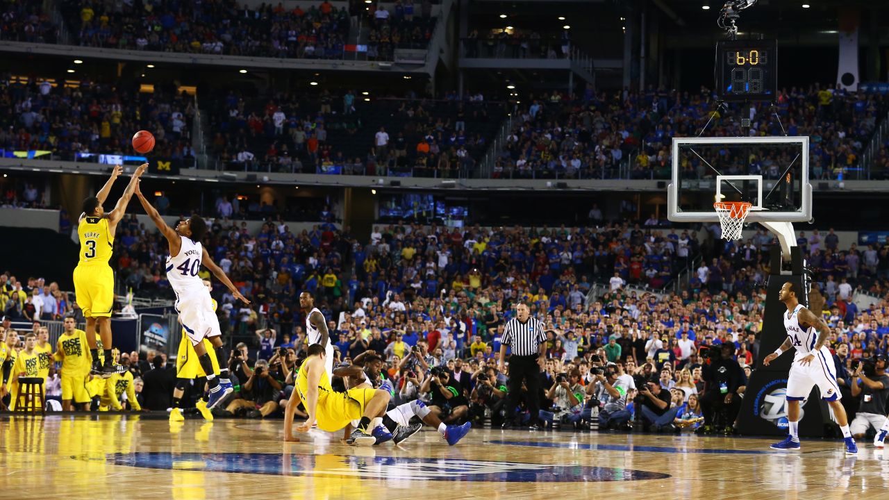 Trey Burke of the Michigan Wolverines shoots a game tying three-pointer in the final seconds of the second half over Kevin Young of the Kansas Jayhawks on March 29 in Arlington, Texas.
