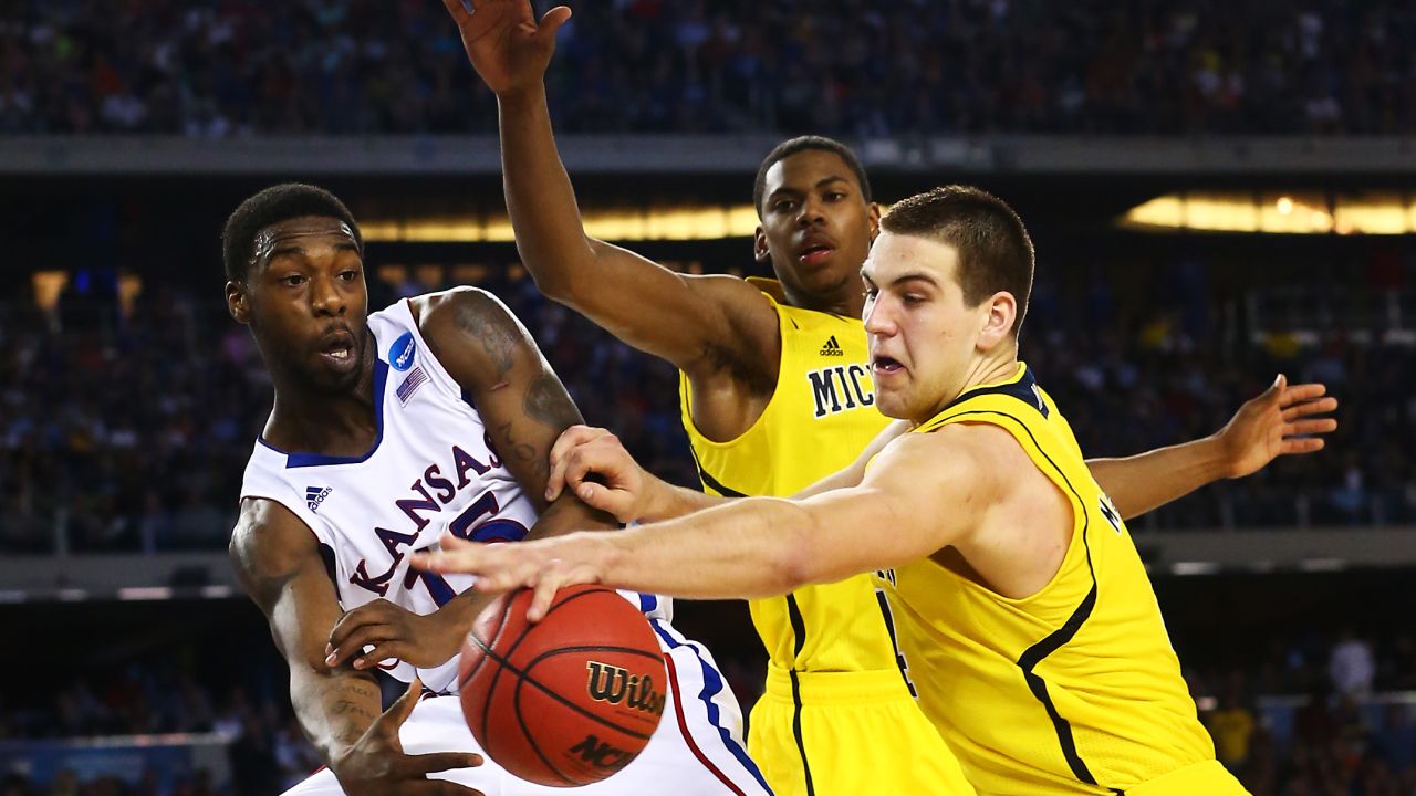 Mitch McGary of Michigan, right, blocks a pass from Elijah Johnson of Kansas in overtime on March 29.