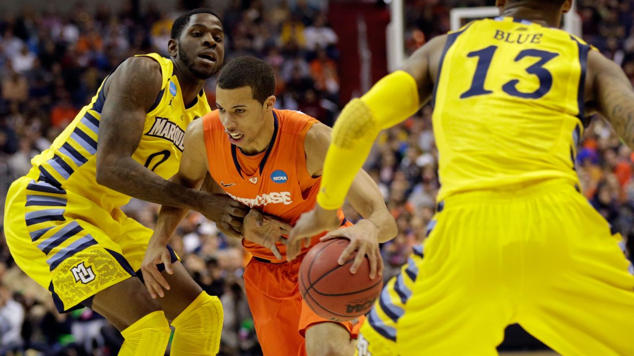 Michael Carter-Williams of Syracuse handles the ball against Jamil Wilson, left, and Vander Blue, right, of Marquette on March 30.