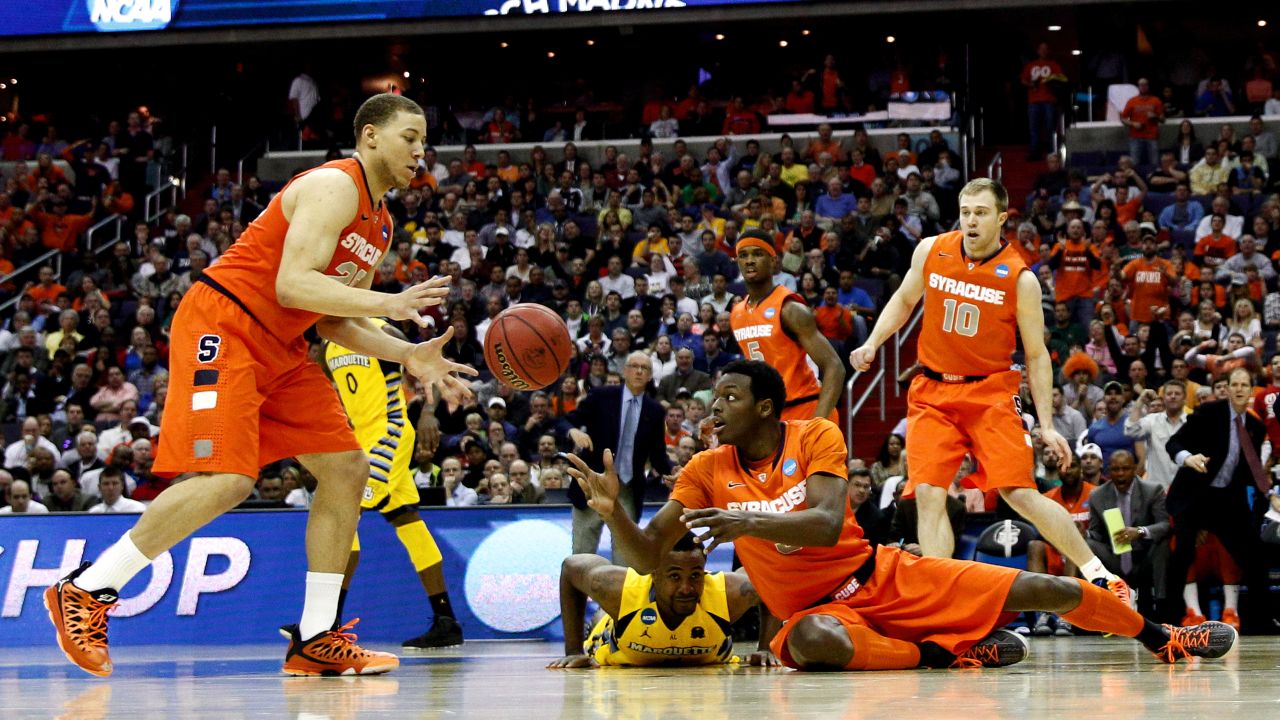 Jerami Grant of Syracuse, bottom right, passes the ball to Brandon Triche, left, from the ground on March 30.