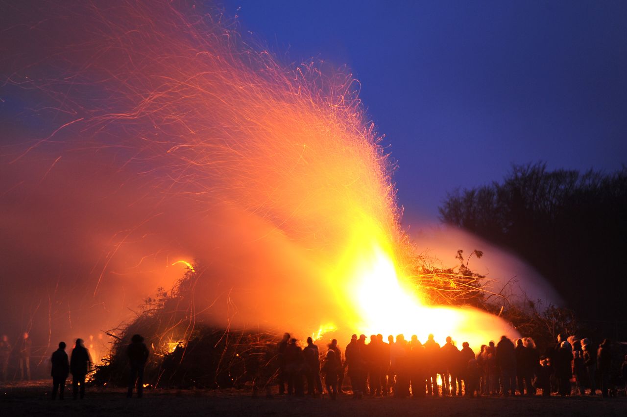 People stand by an Easter fire on Saturday, March 30, in Hellwege, Germany.