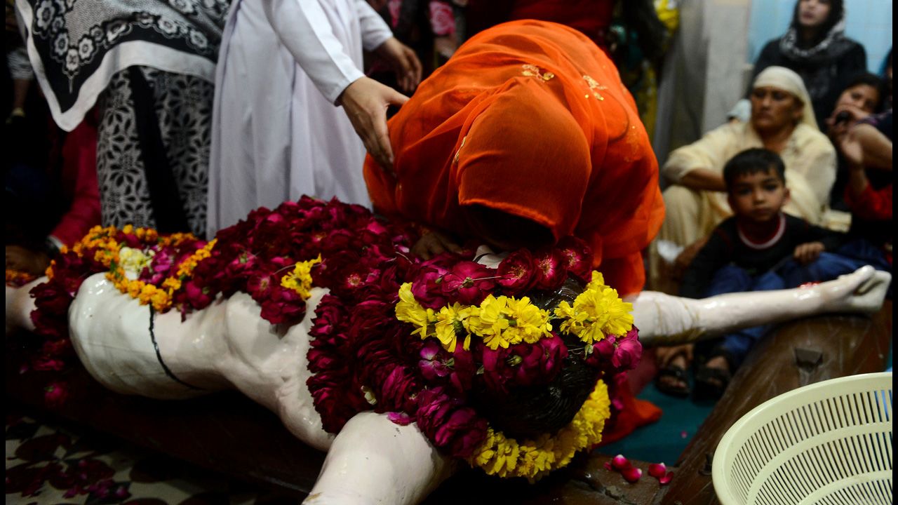 A Christian devotee touches a statue of Christ during a Good Friday service at Saint Francis Church in Lahore, Pakistan, on Friday.
