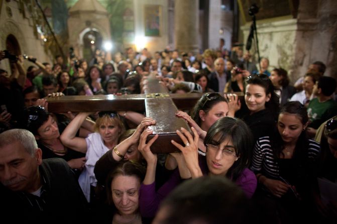 Christian worshippers carry a large wooden cross at the Church of the Holy Sepulchre during the Good Friday procession in Jerusalem's Old City.