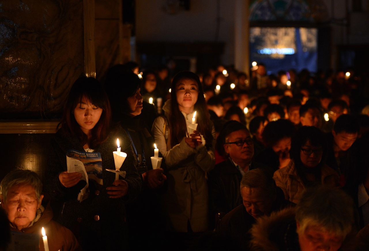 Chinese Catholics hold candles as they pray at the Cathedral of the Immaculate Conception in Beijing on Saturday.