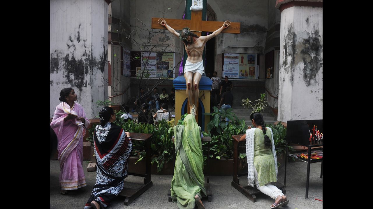 Christians pray in front of a statue of Jesus Christ at a church in Kolkata, India, on Friday.