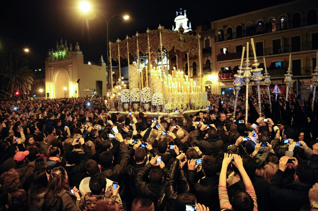Believers gather around the Macarena Virgin during a procession in Seville, Spain, on Friday.