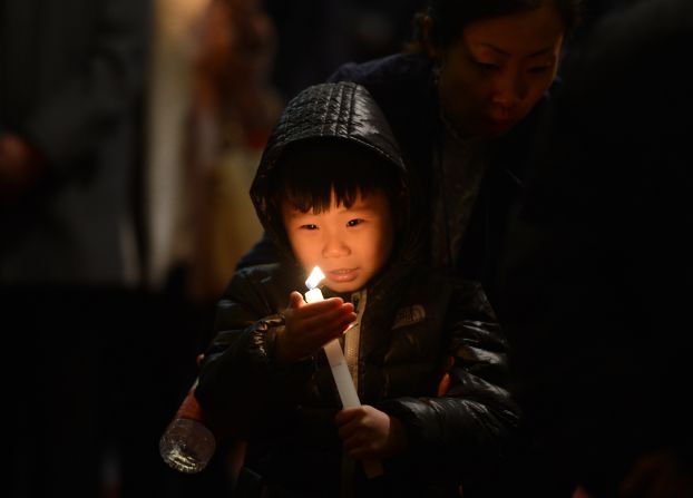 A child holds a candle during an Easter service at the Cathedral of the Immaculate Conception in Beijing on Saturday.
