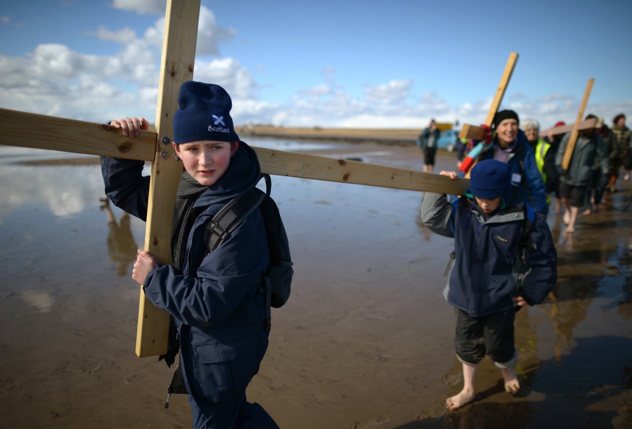 Pilgrims walk with crosses on the final leg of the Northern Cross pilgrimage to Holy Island in Berwick-upon-Tweed, England, on Friday, March 29. More than 50 people, young and old, celebrated Easter by crossing the tidal causeway during the annual Christian pilgrimage.