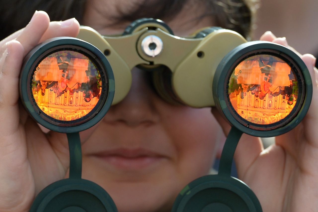 An attendee looks at St. Peter's Basilica through binoculars on Sunday.