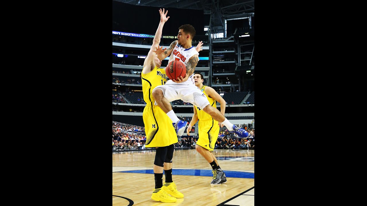 Scottie Wilbekin of Florida goes up against Nik Stauskas, left, of Michigan.