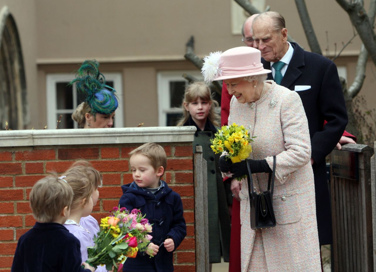 Queen Elizabeth II receives flowers from local children as she leaves the Easter Day service at St. George's Chapel in the grounds of Windsor Castle on March 31.