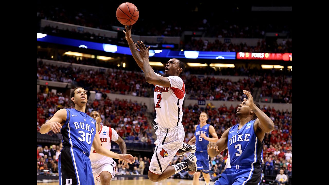 Russ Smith of the Louisville Cardinals drives for a shot attempt against Seth Curry, left, and Tyler Thornton of the Duke Blue Devils on Sunday, March 31, in Indianapolis. Louisville beat Duke 85-63. Check out the action from the fifth round of the 2013 NCAA tournament and <a href="http://www.cnn.com/2013/03/28/worldsport/gallery/ncaa-sweet-16/index.html" target="_blank">look back at the NCAA tournament Sweet 16</a>.