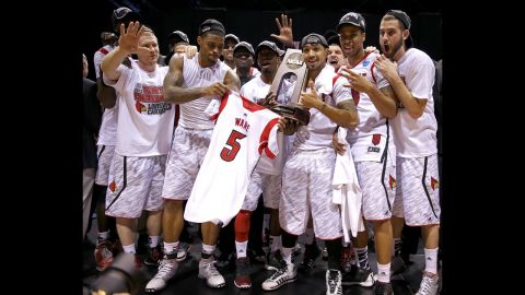 Ware's teammates hold his jersey with the Midwest regional champion trophy after they won 85-63 against Duke.