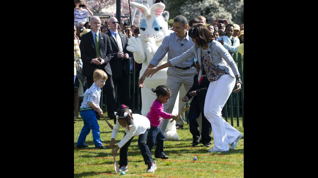 Barack and Michelle Obama cheer on children participating in the egg roll race.
