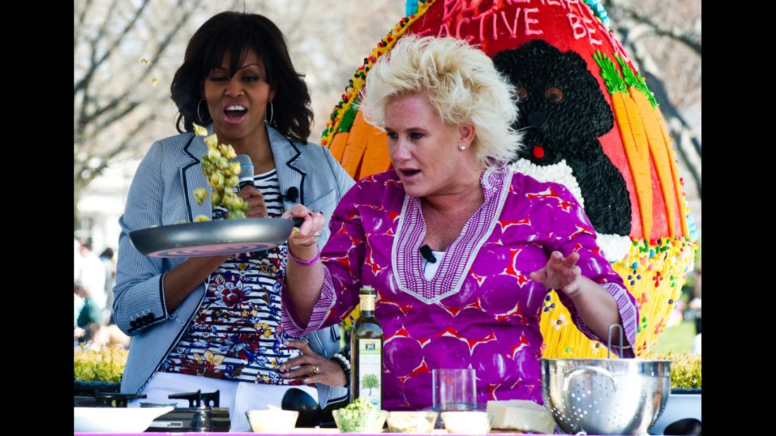 Michelle Obama watches chef Anne Burrell cook.