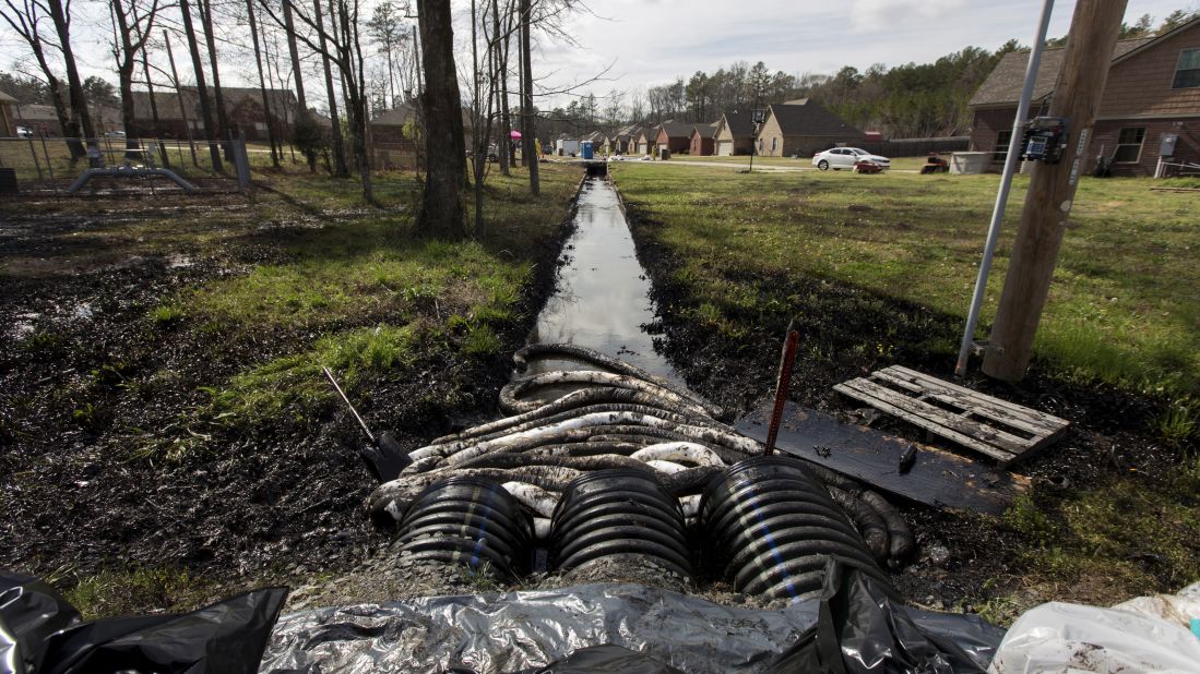 Spilled crude oil is seen in a drainage ditch near evacuated homes in Mayflower, Arkansas, on Sunday, March 31.  An Exxon Mobil pipeline carrying Canadian crude oil ruptured on March 29 causing the evacuation of about two dozen homes. Mayflower residents have filed a class-action lawsuit against the company.