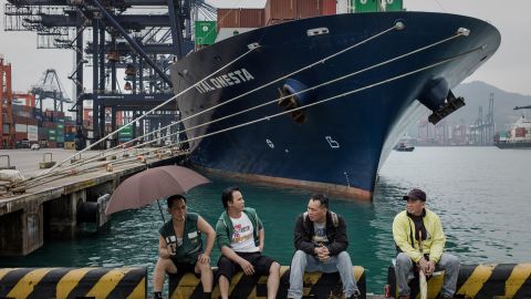 Dockers sit in front of a ship at the Kwai Chung container terminal in Hong Kong on March 29.