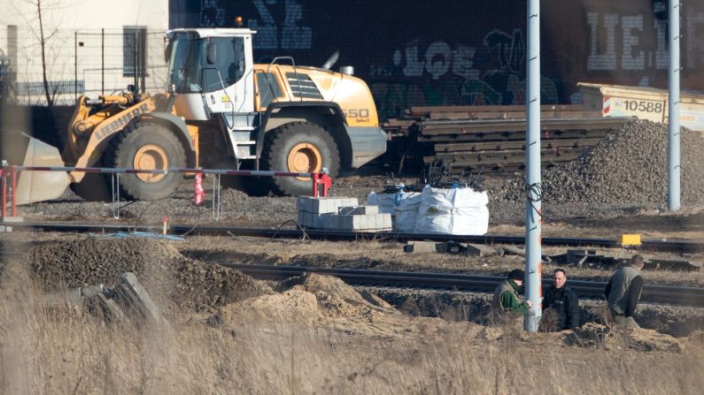 Experts from the bomb disposal team and a police officer stand in a pit next to railway tracks. Some train services were delayed, said a spokesman for German railway operator Deutsche Bahn.