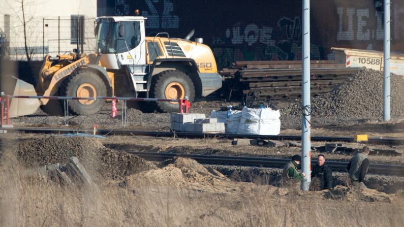 Experts from the bomb disposal team and a police officer stand in a pit next to railway tracks. Some train services were delayed, said a spokesman for German railway operator Deutsche Bahn. 