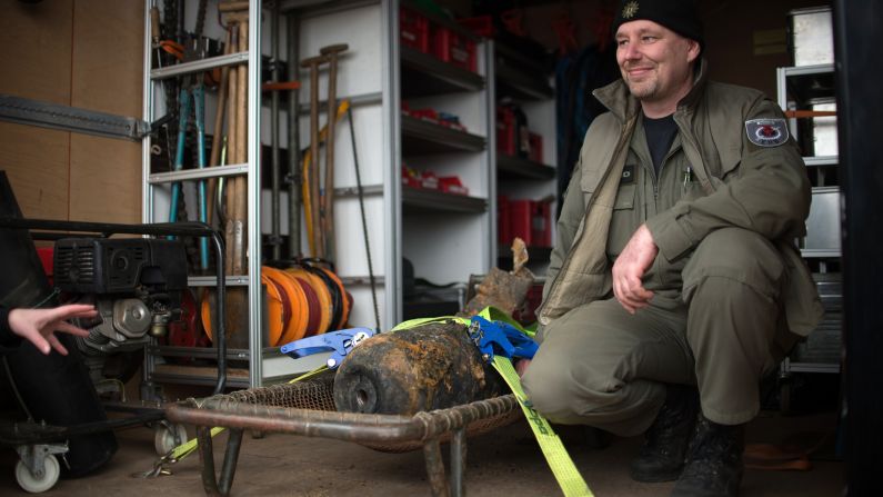 Joerg Neumann of the bomb disposal team poses next to the defused bomb.