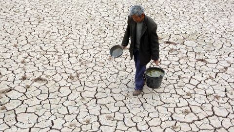 Villager Fu Xianxing, 70, walks on a dried-up field Tuesday, April 2, in Suining, China. A severe drought has caused a shortage of drinking water in the area in southwest China's Sichuan province.