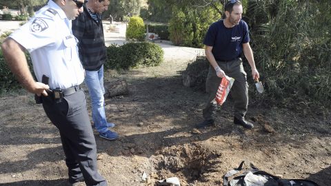 A bomb technician collects the remains of a rocket launched from Gaza Strip falling close to Sderot on April 3, 2013. 