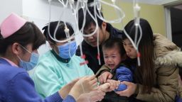 This picture taken on January 13, 2013 shows nurses attending to a young child (C) in hospital for flu treatment in Beijing.